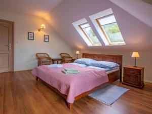 a bedroom with a bed with a pink bedspread and two windows at Holiday Home Sianożęty by Interhome in Sianozety