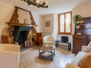 a living room with a fireplace and a table at Apartment della Nonna by Interhome in Musignano