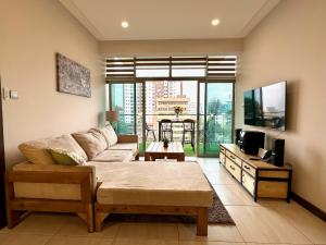 ein Wohnzimmer mit einem Sofa und einem TV in der Unterkunft Skynest - urban luxury apartments by El Mufasa in Nairobi