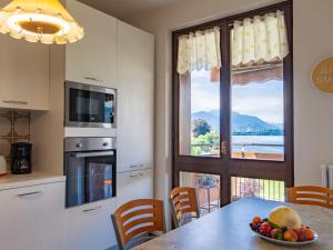 a kitchen with a table with a bowl of fruit on it at Apartment Gaggetto - LVM160 by Interhome in Laveno-Mombello