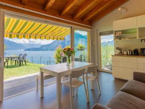 a kitchen with a table with a vase of flowers on it at Holiday Home Lacum Lux Resort by Interhome in Perledo