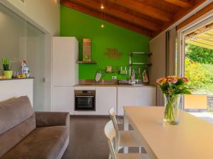 a kitchen with a table and a green wall at Holiday Home Lacum Lux Resort by Interhome in Perledo