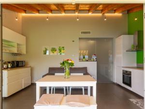 a kitchen with a white table with flowers on it at Holiday Home Lacum Lux Resort by Interhome in Perledo