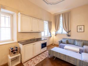 een keuken en een woonkamer met een wastafel en een bank bij Apartment Winery Villa Vitas - App-3 by Interhome in Strassoldo