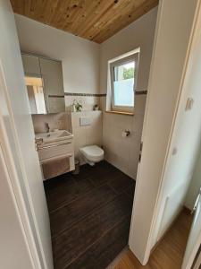 uma casa de banho com um WC, um lavatório e um espelho. em Moderne Ferienwohnung auf Rups Hof em Oberhöcking