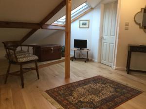 ein Wohnzimmer mit einem Stuhl, einem Teppich und einem Fenster in der Unterkunft Dwynant - A Room with a View in Llangathen