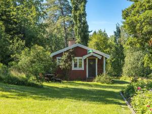 una cabina roja en medio de un patio en Holiday Home Lidelund by Interhome en Tingsryd