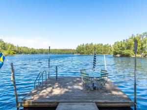 a table and chairs on a dock on a lake at Holiday Home Lidelund by Interhome in Tingsryd