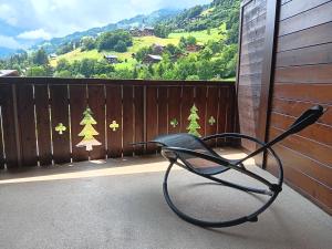 a chair on a balcony with a view of trees at The River Pearl in Val dʼIlliez