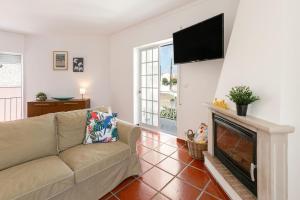 sala de estar con sofá y TV de pantalla plana en Villa Juno, en Atouguia da Baleia