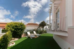 patio con 2 sillas y balcón en Villa Juno, en Atouguia da Baleia