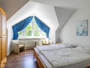 een slaapkamer met een bed en een raam met blauwe gordijnen bij Holiday Home Losentitz by Interhome in Losentitz