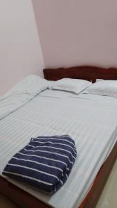 a bed with a blue and white blanket on it at New Homestay in Ha Giang