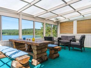 a large screened in porch with a table and chairs at Chalet Uskeboda - VML215 by Interhome in Nora