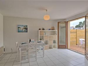 ein weißes Esszimmer mit einem Tisch und Stühlen in der Unterkunft Holiday Home La Criée by Interhome in La Turballe