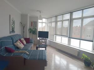 a living room with a blue couch and a television at Albergue Camiño Real in Sigüeiro