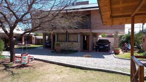 a house with a swing in front of it at Los algarrobos in Villa Carlos Paz