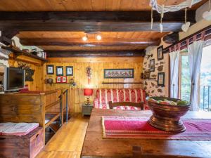 a log cabin bedroom with a couch and a television at Chalet Il Gianlupo by Interhome in Bognanco
