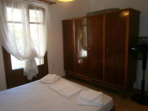 a bedroom with a bed and a dresser and a window at Moraki Apartment in Episkopión
