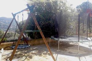 a swing set on a patio with a view at Wonderful house in the mountains with sea views in Cabrils