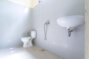 a bathroom with a toilet and a sink at RedDoorz At Pariban Homestay Parbaba in Sinabono