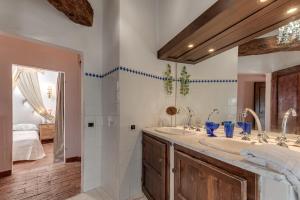 uma casa de banho com 2 lavatórios e um espelho grande em Pent House Duplex em San Donato in Poggio