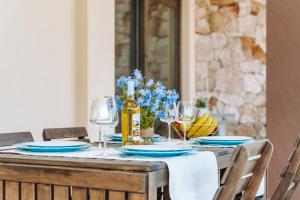 un tavolo in legno con piatti blu e bicchieri da vino di Villa delle Viole a Quartu SantʼElena