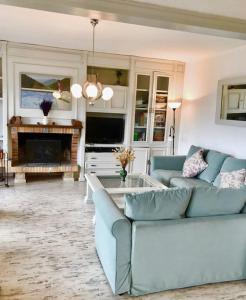 a living room with a blue couch and a fireplace at Wonderful house in the mountains with sea views in Cabrils