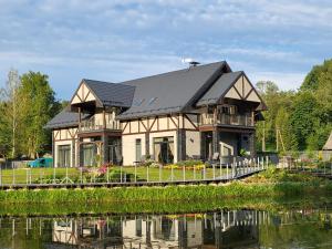 a house on a bridge over a body of water at 9 Garšas in Vildoga