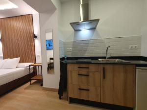 a kitchen with a sink and a bed in a room at El Nogal Home in Málaga