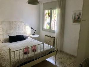 a bedroom with a bed with two pink shoes on it at Wonderful house in the mountains with sea views in Cabrils +52 photos