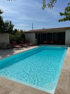 una grande piscina blu di fronte a una casa di Le 240b #1 a Saint-Mard