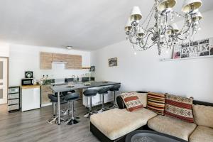 a kitchen and living room with a couch and a table at Le Long du Fleuve - Appt avec balcon vue fleuve in Saint-André-de-Cubzac