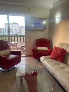 uma sala de estar com um sofá e cadeiras e uma janela em Studio marina em M'diq