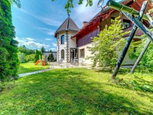 a house with a red roof and a grass yard at Holiday Home Zameczek Falsztyn by Interhome in Falsztyn
