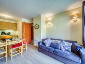 a living room with a couch and a table at Apartment Les Alpages du Corbier-1 by Interhome in Le Corbier