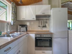 a kitchen with white cabinets and a sink and a refrigerator at Holiday Home Wiesenhütte by Interhome in Rott