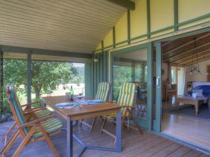 a wooden table and chairs on a screened in porch at Holiday Home Wiesenhütte by Interhome in Rott