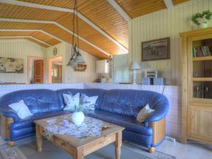a living room with a blue couch and a table at Holiday Home Wiesenhütte by Interhome in Rott +27 photos