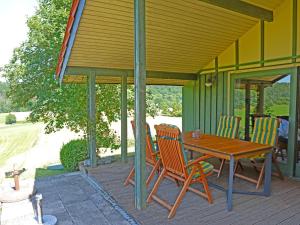 a wooden table and chairs on a patio at Holiday Home Wiesenhütte by Interhome in Rott