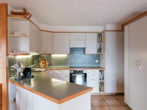 a kitchen with white cabinets and a counter top at Chalet Biquinou by Interhome in Verbier