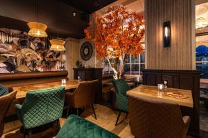 un restaurant avec des tables en bois et des chaises vertes dans l'établissement Hotel Bom, à Burgh-Haamstede