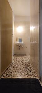 uma casa de banho com lavatório e piso em azulejo em Apartments close to Thalassa em Siolim