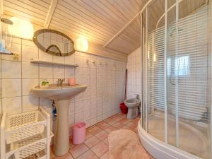 La salle de bains est pourvue d'un lavabo, d'une douche et de toilettes. dans l'établissement Holiday Home Bierna by Interhome, à Bierna