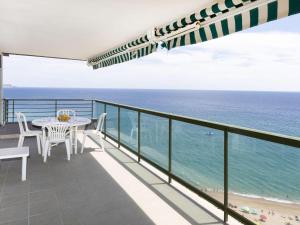 een balkon met een tafel en stoelen en de oceaan bij Apartment Groc by Interhome in Platja  d'Aro