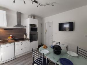 a kitchen with a table and a kitchen with white cabinets at Apartment La Licorne by Interhome in Saint Malo +12 photos