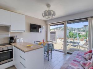 a kitchen and dining room with a view of a patio at Apartment La Madrague d'Azur-9 by Interhome in La Madrague