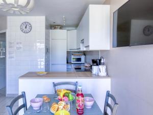 une cuisine avec une table, des chaises et une horloge dans l'établissement Apartment La Madrague d'Azur-9 by Interhome, à La Madrague