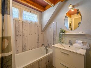 a bathroom with a tub and a sink and a mirror at Studio Phare de Kernevest-1 by Interhome in La Trinité-sur-Mer