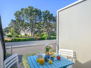 a blue table with fruit and juice on a balcony at Studio Phare de Kernevest-1 by Interhome in La Trinité-sur-Mer